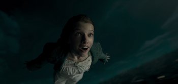 Movie still from “Peter Pan & Wendy” (2023), directed by David Lowery – A young girl in a white dress looking up at the sky; Close Up shot, Overhead angle
