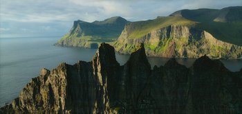 Movie still from “Peter Pan & Wendy” (2023), directed by David Lowery – A view of a body of water with mountains in the background; Extreme Wide shot, High angle