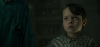 Movie still from “Peter Pan & Wendy” (2023), directed by David Lowery – A young boy is looking up at the camera; Close Up shot, Low angle