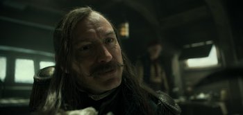 Movie still from “Peter Pan & Wendy” (2023), directed by David Lowery – A person with long hair and a mustache; Close Up shot, Over the shoulder angle