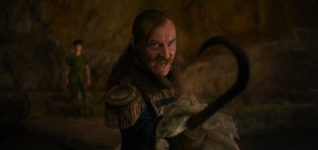 Movie still from “Peter Pan & Wendy” (2023), directed by David Lowery – A man with long hair and a beard is holding an axe; Close Up shot, Low angle