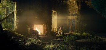 Movie still from “Peter Pan & Wendy” (2023), directed by David Lowery – Two people are sitting in front of an open fire; Extreme Wide shot, Low angle