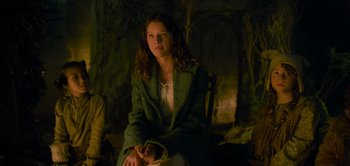 Movie still from “Peter Pan & Wendy” (2023), directed by David Lowery – A woman sitting on a chair in a dark room; Medium shot, Over the shoulder angle
