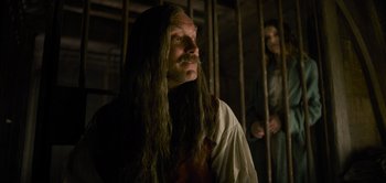 Movie still from “Peter Pan & Wendy” (2023), directed by David Lowery – A man with long hair and a mustache in front of another man; Close Up shot, Low angle