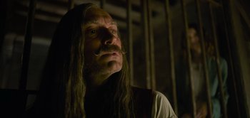 Movie still from “Peter Pan & Wendy” (2023), directed by David Lowery – A man with long hair and a mustache looking up; Close Up shot, Low angle