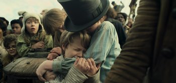 Movie still from “Peter Pan & Wendy” (2023), directed by David Lowery – Two people hugging each other in a crowd of people; Close Up shot, Over the shoulder angle