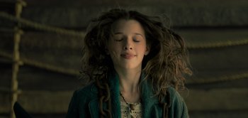 Movie still from “Peter Pan & Wendy” (2023), directed by David Lowery – A young girl with her eyes closed with her hair blowing in the wind; Close Up shot, Low angle