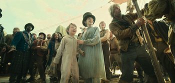 Movie still from “Peter Pan & Wendy” (2023), directed by David Lowery – A group of people standing next to each other on a dock; Medium shot, Low angle