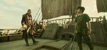Movie still from “Peter Pan & Wendy” (2023), directed by David Lowery – Two people standing on the deck of a boat; Wide shot, Low angle