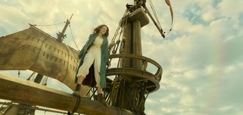 Movie still from “Peter Pan & Wendy” (2023), directed by David Lowery – A woman standing on top of a wooden boat; Wide shot, Low angle
