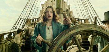Movie still from “Peter Pan & Wendy” (2023), directed by David Lowery – A young woman holding a steering wheel on a boat; Medium shot, Low angle