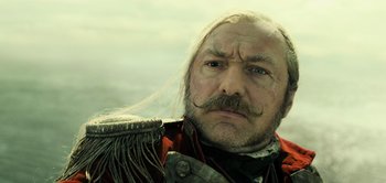 Movie still from “Peter Pan & Wendy” (2023), directed by David Lowery – A person with a beard and mustache; Close Up shot, Low angle