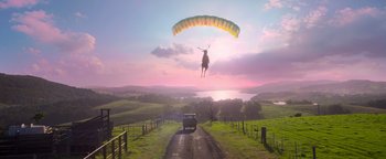Movie still from “Peter Rabbit 2: The Runaway” (2021), directed by Will Gluck – A car driving down a road under a parachute with an animal on it; Extreme Wide shot, Low angle