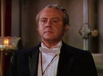 Movie still from “Phantom of the Opera” (1943), directed by Arthur Lubin – An older man in a suit and bow tie; Close Up shot, Low angle