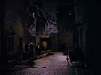 Movie still from “Phantom of the Opera” (1943), directed by Arthur Lubin – A group of people standing on a street at night; Extreme Wide shot, High angle