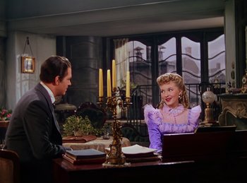 Movie still from “Phantom of the Opera” (1943), directed by Arthur Lubin – A man and a woman sitting at a table; Medium shot, Over the shoulder angle