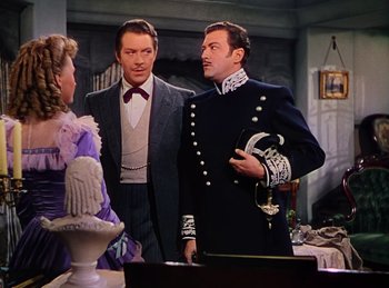 Movie still from “Phantom of the Opera” (1943), directed by Arthur Lubin – A man in a suit standing next to two other men; Medium shot, Over the shoulder angle