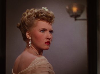 Movie still from “Phantom of the Opera” (1943), directed by Arthur Lubin – A woman in a dress with a bow in her hair; Close Up shot, Over the shoulder angle