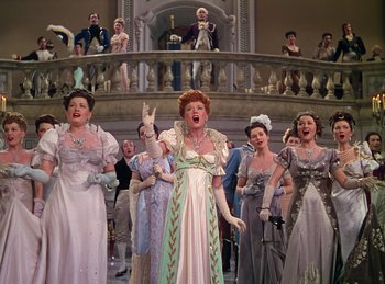 Movie still from “Phantom of the Opera” (1943), directed by Arthur Lubin – A group of people in fancy dresses singing; Wide shot, Low angle
