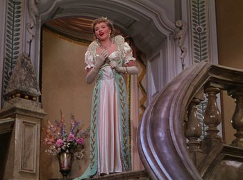 Movie still from “Phantom of the Opera” (1943), directed by Arthur Lubin – A woman in a white dress standing on a staircase; Wide shot, Low angle