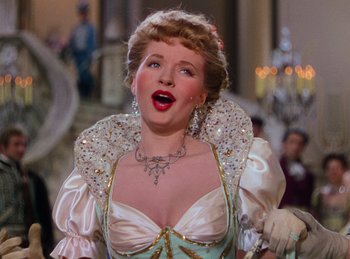 Movie still from “Phantom of the Opera” (1943), directed by Arthur Lubin – A woman wearing a white dress and a necklace; Close Up shot, Low angle