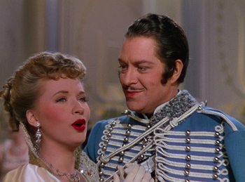 Movie still from “Phantom of the Opera” (1943), directed by Arthur Lubin – A man and a woman standing next to each other; Medium shot, Over the shoulder angle