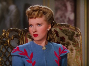 Movie still from “Phantom of the Opera” (1943), directed by Arthur Lubin – A woman in a blue dress sitting in a chair; Close Up shot, Over the shoulder angle