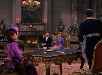 Movie still from “Phantom of the Opera” (1943), directed by Arthur Lubin – A group of people sitting around a table in front of a fireplace; Wide shot, Over the shoulder angle