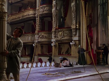 Movie still from “Phantom of the Opera” (1943), directed by Arthur Lubin – Two people sitting on the floor of an old theater; Wide shot, Low angle