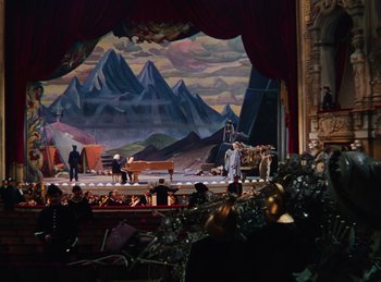 Movie still from “Phantom of the Opera” (1943), directed by Arthur Lubin – A scene of a stage with a mountain backdrop; Extreme Wide shot, High angle