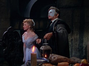 Movie still from “Phantom of the Opera” (1943), directed by Arthur Lubin – A man and a woman wearing masks in a room; Medium shot, Over the shoulder angle
