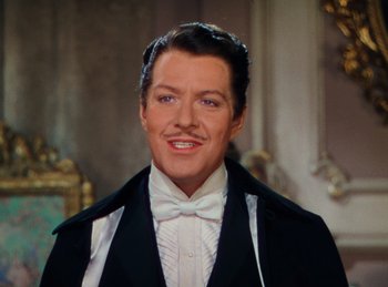 Movie still from “Phantom of the Opera” (1943), directed by Arthur Lubin – A person wearing a suit and a bow tie; Close Up shot, High angle