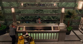 Movie still from “Philadelphia” (1993), directed by Jonathan Demme – A man standing at the front desk of a building; Extreme Wide shot, High angle
