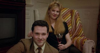 Movie still from “Philadelphia” (1993), directed by Jonathan Demme – A man and a woman sitting in a chair holding a wine glass; Close Up shot, High angle