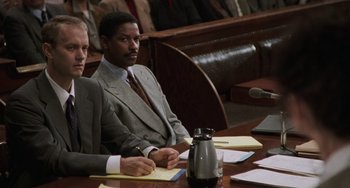 Movie still from “Philadelphia” (1993), directed by Jonathan Demme – Two men sitting at a table in front of a microphone; Medium shot, Over the shoulder angle