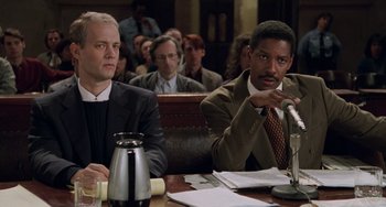 Movie still from “Philadelphia” (1993), directed by Jonathan Demme – Two men sitting at a table in front of a microphone; Medium shot, Low angle