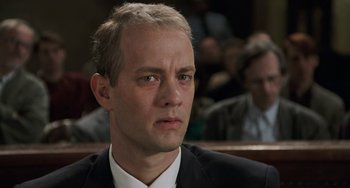 Movie still from “Philadelphia” (1993), directed by Jonathan Demme – A man in a suit sitting in front of a crowd; Close Up shot, Low angle