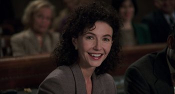 Movie still from “Philadelphia” (1993), directed by Jonathan Demme – A woman with curly black hair smiling for the camera; Close Up shot, Low angle