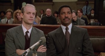 Movie still from “Philadelphia” (1993), directed by Jonathan Demme – Two men in suits and ties in front of a crowd; Medium shot, Low angle