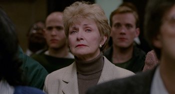 Movie still from “Philadelphia” (1993), directed by Jonathan Demme – An older woman in a crowd of people; Close Up shot, Over the shoulder angle