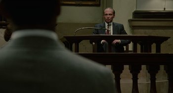 Movie still from “Philadelphia” (1993), directed by Jonathan Demme – A man in a suit sitting in front of a judge; Medium shot, Over the shoulder angle
