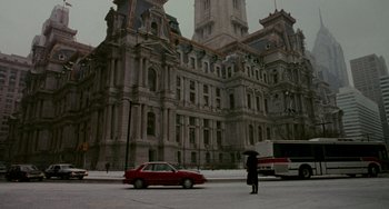 Movie still from “Philadelphia” (1993), directed by Jonathan Demme – A person standing on the side of a road near a building; Extreme Wide shot, High angle