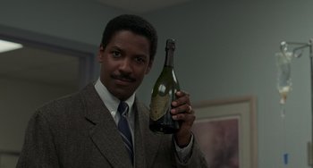 Movie still from “Philadelphia” (1993), directed by Jonathan Demme – A man in a suit holding up a bottle of champagne; Close Up shot, Low angle