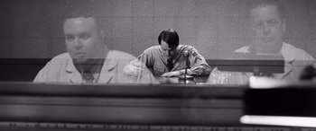 Movie still from “Pineapple Express” (2008), directed by David Gordon Green – A man sitting at a table writing on a piece of paper; Medium shot, Over the shoulder angle