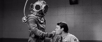 Movie still from “Pineapple Express” (2008), directed by David Gordon Green – A man in a diving suit is feeding a man; Medium shot, High angle