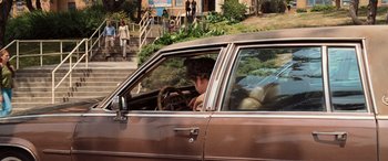 Movie still from “Pineapple Express” (2008), directed by David Gordon Green – A man sitting in the driver's seat of an old car; Wide shot, High angle