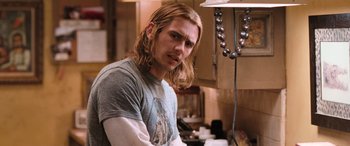 Movie still from “Pineapple Express” (2008), directed by David Gordon Green – A man with long blonde hair is sitting in a kitchen; Close Up shot, Over the shoulder angle