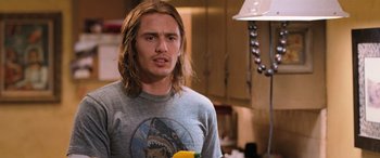 Movie still from “Pineapple Express” (2008), directed by David Gordon Green – A man with long blonde hair holding a yellow pepper; Close Up shot, Over the shoulder angle
