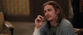 Movie still from “Pineapple Express” (2008), directed by David Gordon Green – A man with long hair is talking on a cell phone; Close Up shot, Low angle