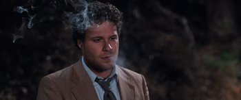Movie still from “Pineapple Express” (2008), directed by David Gordon Green – A man in a suit and tie smoking a cigarette; Close Up shot, Low angle